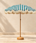 Teal, pink and white striped umbrella with cream fringe, wooden pole and weighted base.