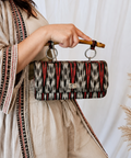 Woman holding a handcrafted Filipino Ikat bamboo handle clutch bag showcasing artisan craftsmanship and sustainable fashion.