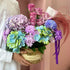 Bouquet of colorful flowers held by a Emirati against a pink background