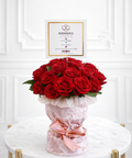 Luxury red rose flower arrangement in pink velvet wrap by Danaya’s Flowers Abu Dhabi