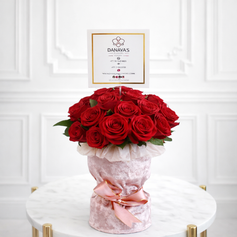 Luxury red rose flower arrangement in pink velvet wrap by Danaya’s Flowers Abu Dhabi