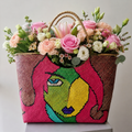 Luxury fresh flower arrangement in a handcrafted Filipino woven artisan basket featuring pink roses, lilies, carnations, lisianthus, and seasonal flowers by Danaya's Flowers Abu Dhabi.