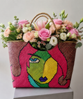 Luxury fresh flower arrangement in a handcrafted Filipino woven artisan basket featuring pink roses, lilies, carnations, lisianthus, and seasonal flowers by Danaya's Flowers Abu Dhabi.
