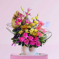 Colorful flower bouquet with pink roses and lilies on a light pink background