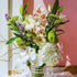 Bouquet of flowers in a clear vase against a pink wall