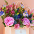 Bouquet of flowers in a clear vase against a pink wall