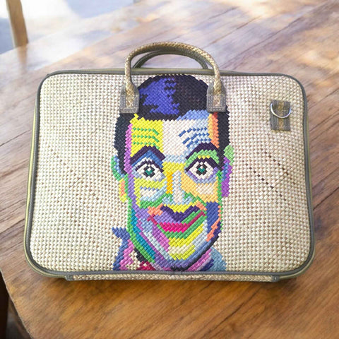 laptop bag with a colorful portrait on a wooden surface