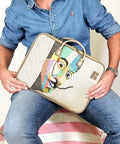Person holding a decorative laptop bag with a colorful man design.