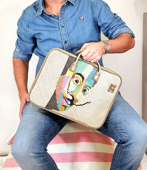 Person holding a colorful laptop bag with a man design