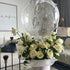 Decorative arrangement with white roses and a transparent bubble containing text in a modern living room.