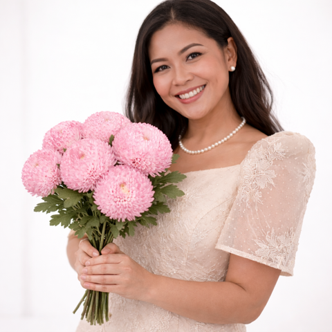 Woman holding a bouquet of pink flowers against a white background