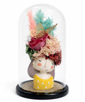 Handcrafted preserved flower arrangement in a glass dome with girl figurine, pastel florals, luxury gift decor on white background