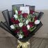 Bouquet of red and white roses with a gold bow on a neutral background
