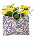 Woven bag with floral arrangement on a white background