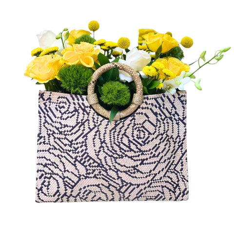 Woven bag with floral arrangement on a white background