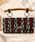 Handwoven Filipino tinalak clutch bag with natural bamboo handle and silver twist-lock closure.